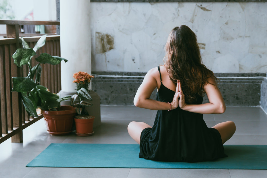 A young woman sitting in a yoga pose in a modern office space